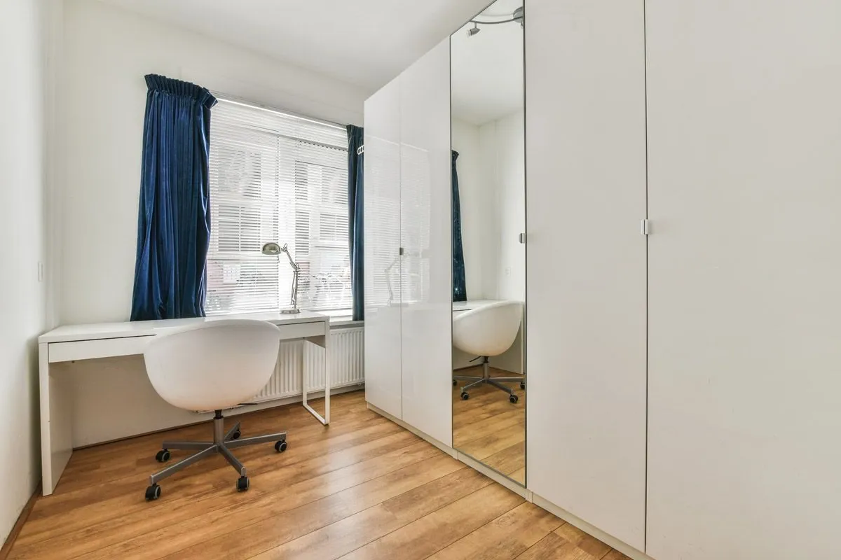 Sliding mirror doors across a full bedroom wall